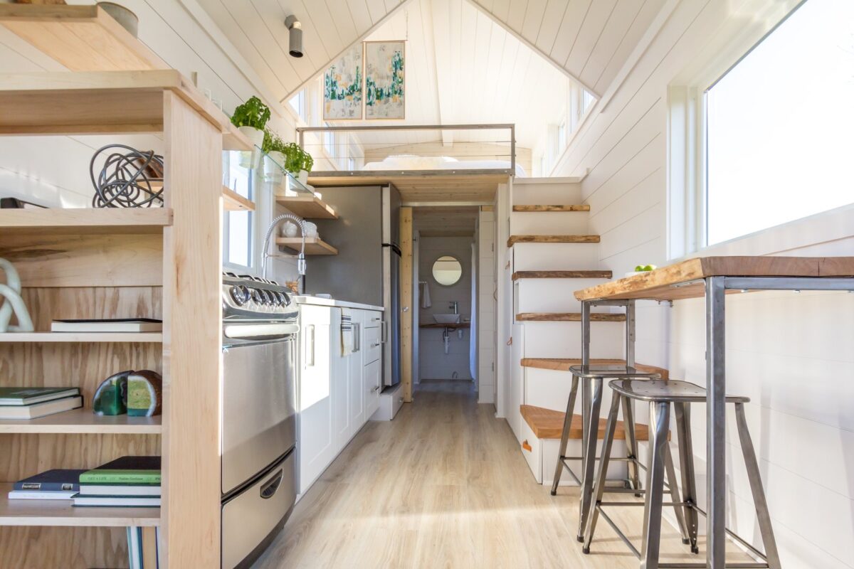 sunlight-bounces-off-white-painted-shiplap-walls-in-the-kitchen-and-the-sleeping-loft-the-flooring-is-from-pergo